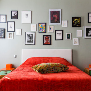 Cette photo montre une chambre tendance avec un mur gris et un sol en bois brun.