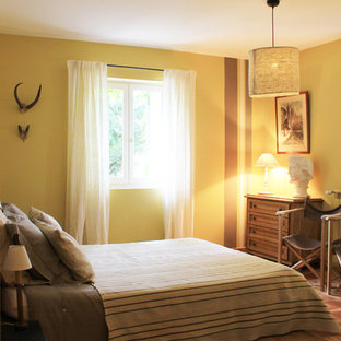 Imagen de dormitorio principal, contemporáneo, grande, sin chimenea, con paredes amarillas, suelo de baldosas de terracota y suelo rojo