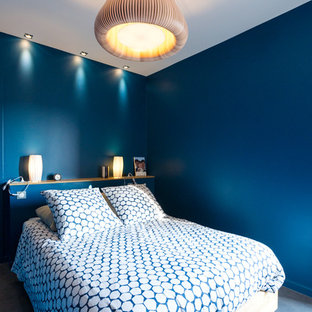Ejemplo de dormitorio principal, actual, de tamaño medio, con paredes azules, suelo de cemento y suelo gris