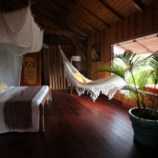 Exemple d'une chambre parentale exotique de taille moyenne avec un sol en bois foncé et aucune cheminée.