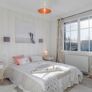 Aménagement d'une chambre contemporaine avec un mur gris, un sol en bois brun et un sol beige.