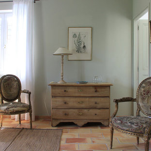 Modelo de dormitorio principal, grande, sin chimenea, con suelo de baldosas de terracota, suelo rojo y paredes verdes