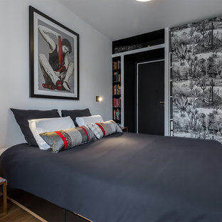 Inspiration pour une chambre parentale design de taille moyenne avec un mur blanc, un sol en bois clair et un sol beige.