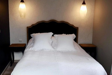 Imagen de dormitorio principal romántico de tamaño medio con paredes grises, suelo laminado y suelo beige