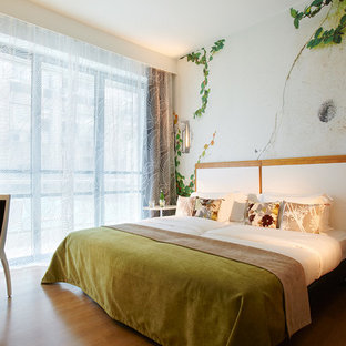 Inspiration pour une chambre parentale design de taille moyenne avec un mur multicolore et un sol en bois brun.
