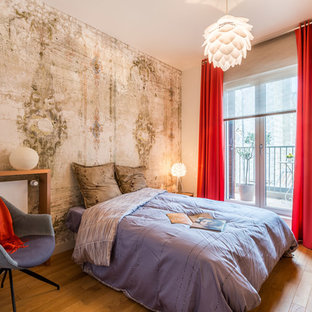 Réalisation d'une chambre design avec un mur blanc et un sol en bois brun.