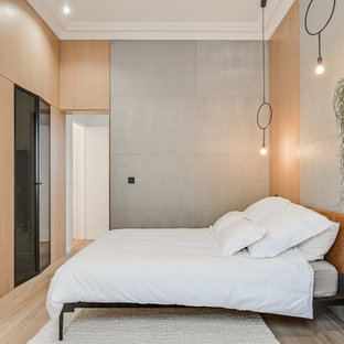 Cette photo montre une chambre parentale scandinave de taille moyenne avec un mur gris, un sol en bois clair et aucune cheminée.