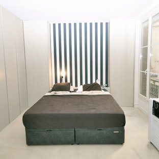 Foto de dormitorio principal, contemporáneo, grande, con paredes azules, suelo de cemento, chimenea tradicional, marco de chimenea de yeso y suelo beige