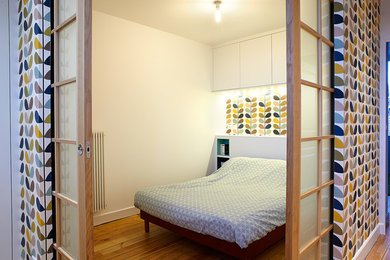 Foto di una camera matrimoniale minimal di medie dimensioni con pareti bianche, parquet chiaro e pavimento marrone