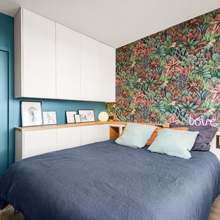 Idées déco pour une chambre contemporaine avec un mur bleu, un sol en bois clair et un sol beige.