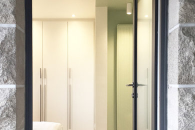 Exemple d'une chambre parentale tendance de taille moyenne avec un mur vert, parquet clair et du papier peint.