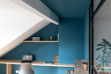 Cette image montre une grande chambre parentale traditionnelle avec un mur bleu et parquet clair.