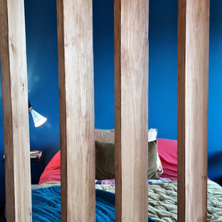 Diseño de dormitorio pequeño con paredes azules, suelo de madera clara y suelo naranja