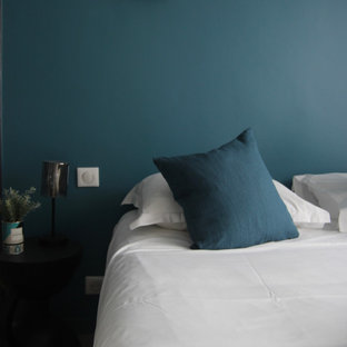 Imagen de habitación de invitados tradicional renovada, de tamaño medio, sin chimenea, con paredes azules, suelo de contrachapado y suelo marrón