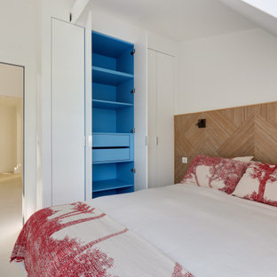 Modelo de dormitorio tipo loft, contemporáneo, de tamaño medio, con paredes blancas, suelo de baldosas de cerámica y suelo beige