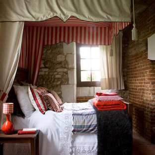 Cette image montre une chambre parentale traditionnelle de taille moyenne avec un mur multicolore et un sol en carreau de terre cuite.