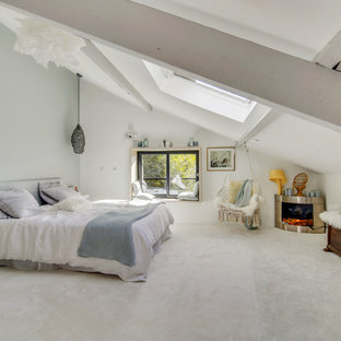Réalisation d'une grand chambre design avec un mur blanc, un manteau de cheminée en métal, un sol blanc et une cheminée d'angle.