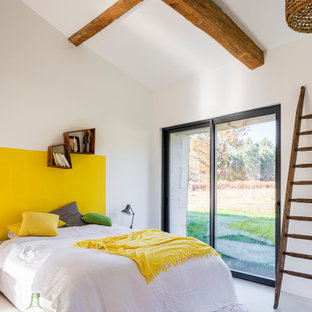 Cette photo montre une chambre tendance avec un mur blanc et un sol gris.