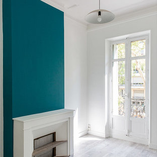 Ejemplo de habitación de invitados actual, de tamaño medio, con paredes blancas, suelo laminado, chimenea tradicional, marco de chimenea de ladrillo y suelo gris