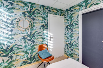 Foto de dormitorio tropical con paredes verdes, suelo laminado y suelo beige