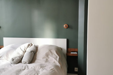 Exemple d'une petite chambre parentale chic avec un mur vert, un sol en bois brun et une cheminée standard.