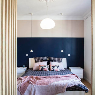 Inspiration pour une chambre design avec un mur rose, un sol en bois brun et un sol marron.