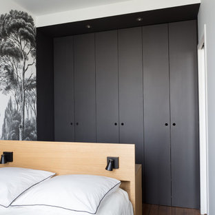 Imagen de dormitorio escandinavo, pequeño, con paredes negras, suelo de madera en tonos medios y suelo beige