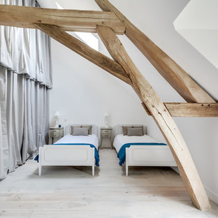 Aménagement d'une grand chambre parentale scandinave avec un mur blanc, un sol en bois clair et un sol blanc.