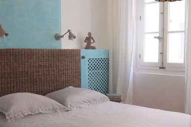 Inspiration pour une chambre d'amis méditerranéenne de taille moyenne avec un mur bleu et un sol en bois brun.