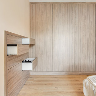 Ejemplo de dormitorio principal, de estilo de casa de campo, de tamaño medio, sin chimenea, con parades naranjas y suelo de madera clara