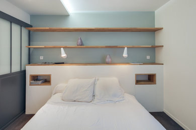 Idée de décoration pour une chambre minimaliste de taille moyenne avec un mur bleu, aucune cheminée et un sol gris.