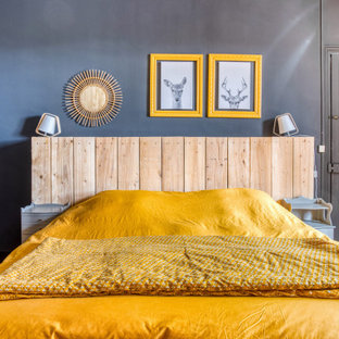 Idee per una grande camera matrimoniale minimal con pareti grigie, parquet chiaro, camino classico, pavimento marrone e cornice del camino in pietra