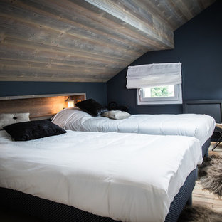 Imagen de habitación de invitados rústica con paredes azules, suelo de madera clara y suelo beige