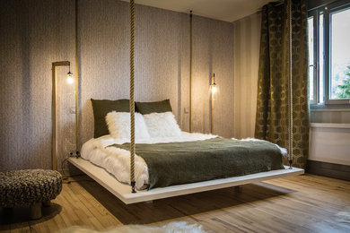 Foto di una camera da letto contemporanea con pareti grigie, parquet chiaro e pavimento beige