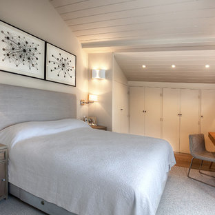 Exemple d'une chambre tendance avec un mur gris, un sol en bois brun et aucune cheminée.