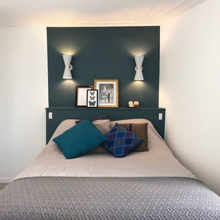 Diseño de dormitorio principal, moderno, de tamaño medio, con paredes verdes, suelo de linóleo, chimenea de esquina, marco de chimenea de piedra y suelo gris