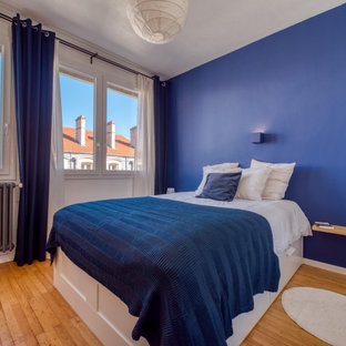 Diseño de dormitorio principal, actual, de tamaño medio, sin chimenea, con paredes azules, suelo de madera clara y suelo beige