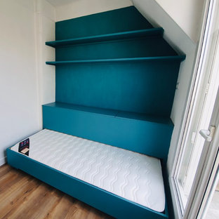Diseño de dormitorio tipo loft, contemporáneo, pequeño, con paredes azules y suelo laminado