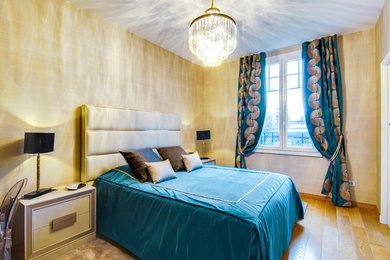 Klassisk inredning av ett stort sovrum, med beige väggar och ljust trägolv