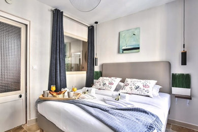 パリにある中くらいなおしゃれな主寝室 (グレーの壁、テラコッタタイルの床、暖炉なし、茶色い床)