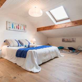 Inspiration pour une chambre marine avec un mur blanc et un sol en bois clair.