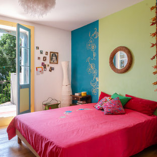 Diseño de dormitorio bohemio con paredes azules, suelo de madera en tonos medios y suelo marrón