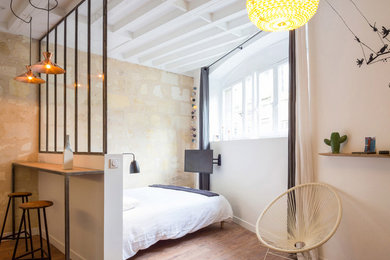 Kleines Modernes Schlafzimmer ohne Kamin mit weißer Wandfarbe und braunem Holzboden in Bordeaux