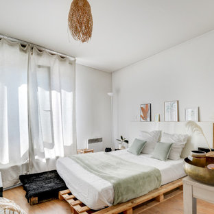 Aménagement d'une chambre exotique avec un mur blanc, un sol en bois brun et un sol marron.