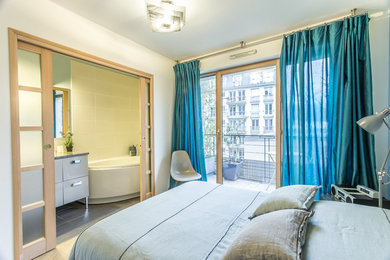 Ejemplo de dormitorio principal contemporáneo de tamaño medio con paredes blancas, suelo laminado y suelo beige