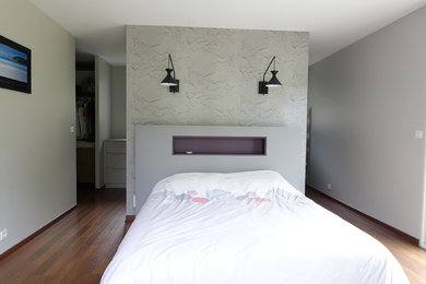 Exemple d'une chambre tendance avec un mur gris et sol en stratifié.