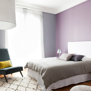 Réalisation d'une chambre vintage avec un mur multicolore et un sol en bois brun.