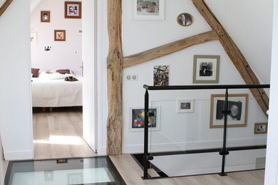 Exemple d'une chambre parentale chic de taille moyenne avec un mur blanc, parquet clair, aucune cheminée et un sol beige.