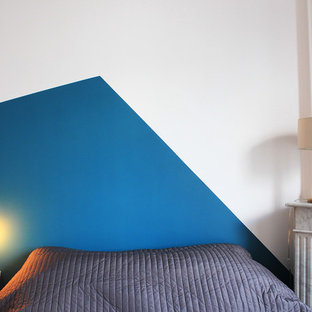 Foto de dormitorio principal, contemporáneo, pequeño, con paredes blancas, suelo de madera clara, chimenea de esquina y marco de chimenea de piedra