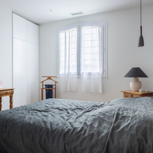 Réalisation d'une chambre parentale design avec un mur blanc.
